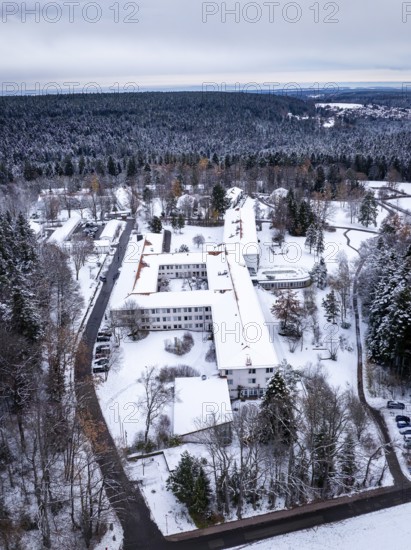 A snow-covered building in the middle of a wooded winter landscape mountain, Rehab Clinic,