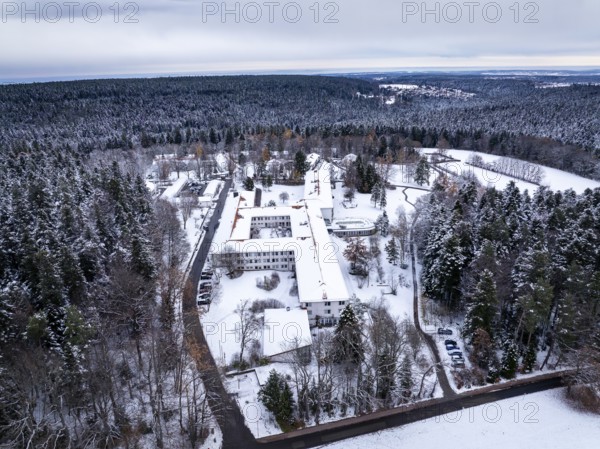 Snowy landscape with buildings surrounded by thick forests and a wide sky, rehab clinic, Schömberg,