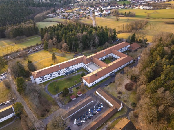 Building complex surrounded by fields in a rural village, from an aerial view, rehab clinic,