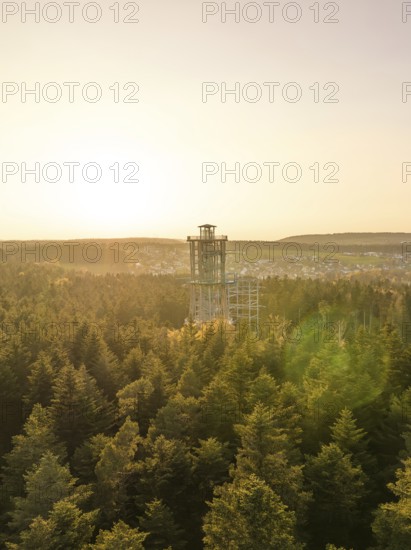 Wooded landscape with a panoramic tower in the distance at sunset, Himmelsglück observation tower
