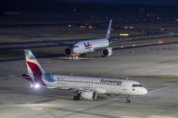 FedEx Boeing 777-FS2 cargo plane is towed to take off, at Cologne/Bonn airport, Eurowings aircraft