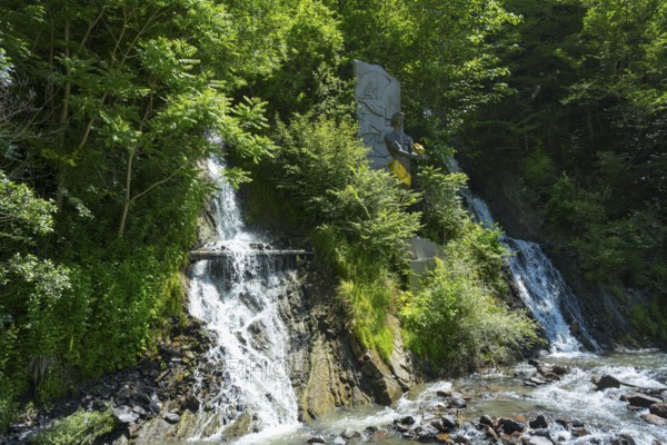 Double waterfall in dense vegetation flows into a river, Borjomi resort, Borjomi, waterfall in