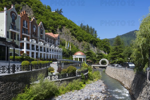 Hotel on a river surrounded by green mountains and vegetation in sunny weather, Hotel Crowne Plaza