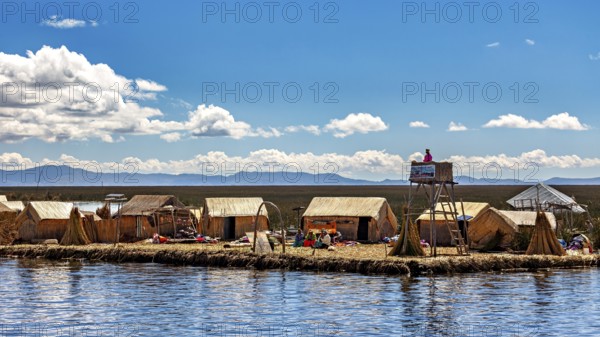 Reed huts and people on an island under a partly cloudy sky with a wide landscape, The floating