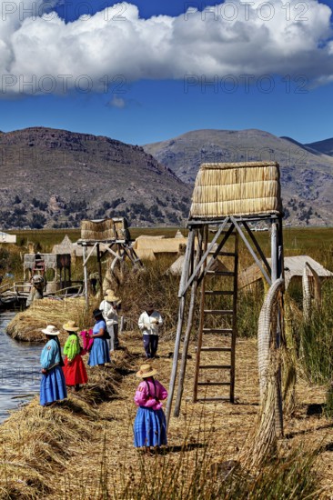 Women in traditional clothing at an elevated point overlooking the water, The floating reed islands