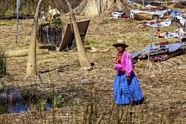A woman in traditional dress stands in a quiet village made of reeds, The floating reed islands of