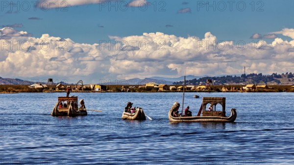 People ride in artfully designed reed boats on a wide lake, The floating reed islands of the Uros