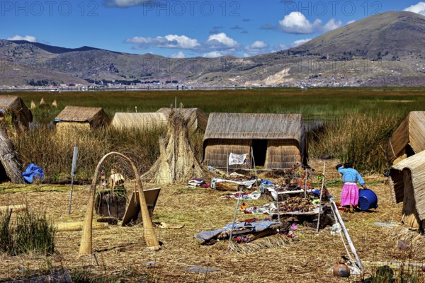 Reed huts with mountains in the background and scattered crafts, The floating reed islands of the
