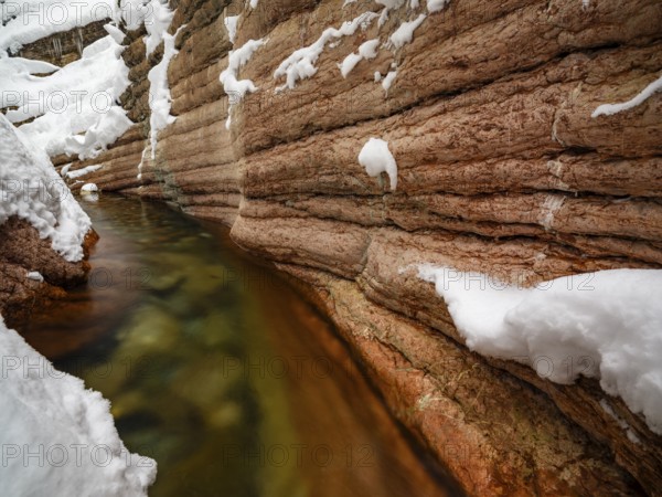 Taugl or Tauglbach flows through the snow-covered and icy red gorge, also Marmorklamm, Bad Vigaun,