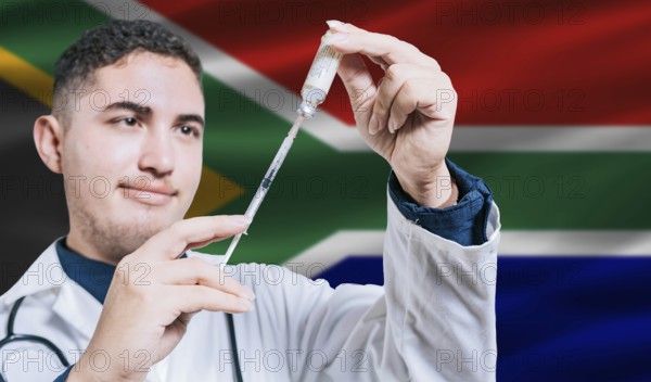 Doctor holding syringe on South Africa flag background. Medical professional holding syringe with