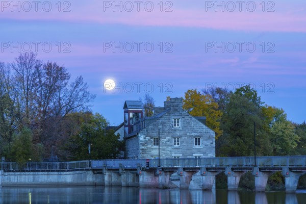 Illuminated Moulin Neuf water flow control dam and walkway over Des Mille-Iles river plus New Mill