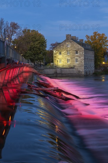Illuminated Moulin Neuf water flow control dam and walkway over Des Mille-Iles river plus New Mill