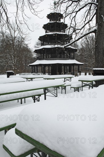 Winter in the English Garden, snow-covered beer garden tables and benches, Chinese Tower, Munich,
