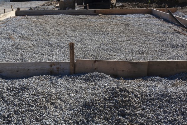Wooden concrete pouring forms and bed of crushed and compacted stone aggregate to rest concrete
