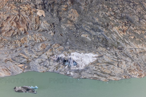 Remains of the Rhone Glacier ice cave covered with protective white geotextile sheets, highlighting