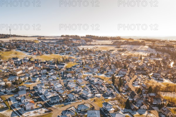 Bird's-eye view of rural winter landscape with snow-covered houses and fields, Hallwangen,