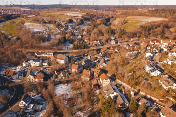 Snowy village spread over rolling hills with a clear view of the surrounding area, Aach,