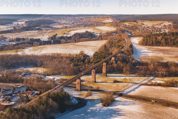Winter landscape with a railroad bridge across fields and snow-covered hills, Dornstetten,