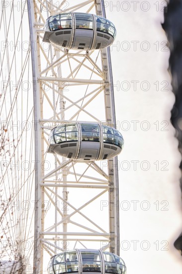 Close-up of a Ferris wheel with futuristic cabins against a bright sky, London Eye, London, United