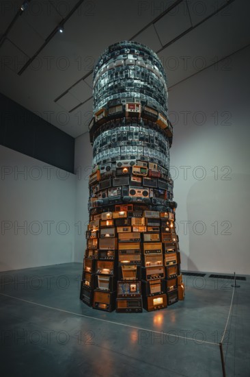 A tall tower of stacked radios with illuminated elements in the museum, Tate Modern of Art, Lodon,