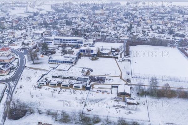 Modern and traditional buildings in a snowy village with streets and squares, Empfingen,