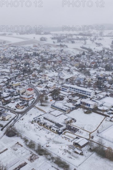 Aerial view of a snowy village with houses, roads and surrounding fields, Empfingen, Freudenstadt