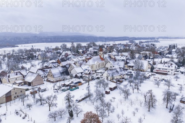 Snowy village with church in the center, surrounded by winter landscape, Wiesenstetten,
