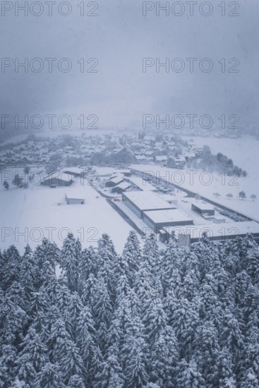 Snowy village on the edge of a forest under cloudy sky, Hörschweiler, Freudenstadt district,