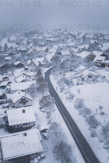 Snowy village with snow-covered houses and roads under cloudy sky, Schopfloch, Freudenstadt