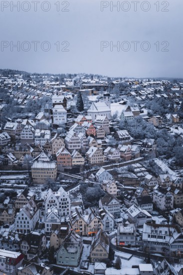 Snowy town with half-timbered houses and church, surrounded by winter landscape, Altensteig, Calw