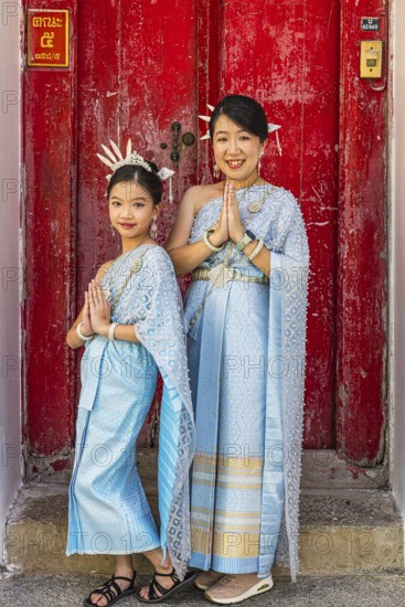 Mother and daughter in traditional clothing present themselves for the photographers, Wat Arun