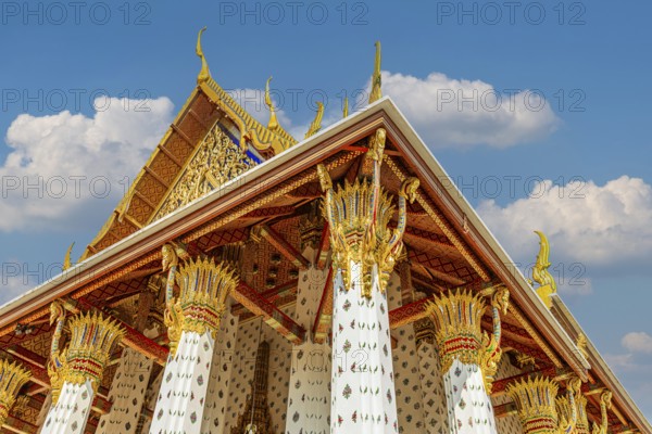 Columns with floral motifs support the gold-colored ceiling of the Wat Arun Buddhist temple,