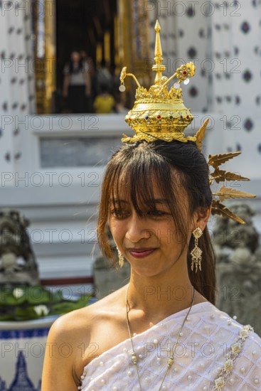 Young woman with traditional headdress, wearing traditional clothing, presenting herself to the