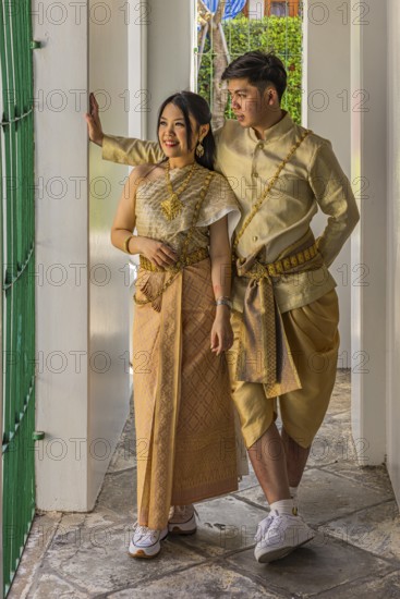 Young woman and young man in traditional clothing present themselves for the photographers, Wat