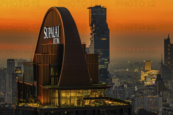 Over the rooftops of Bangkok, sunset, roof structure of the luxury residential residence Supalai
