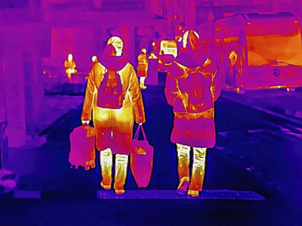 Thermal image or thermography, symbolic photo, interpolated. People traveling in urban areas.