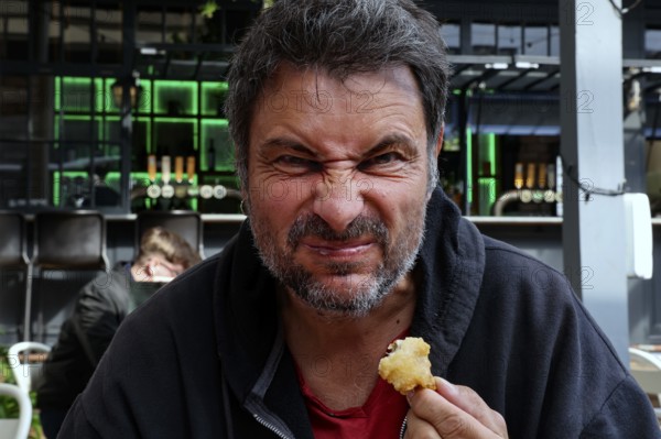 Man tries fried oysters at Wynard Quarter fish market in Auckland, Auckland, North Island, New