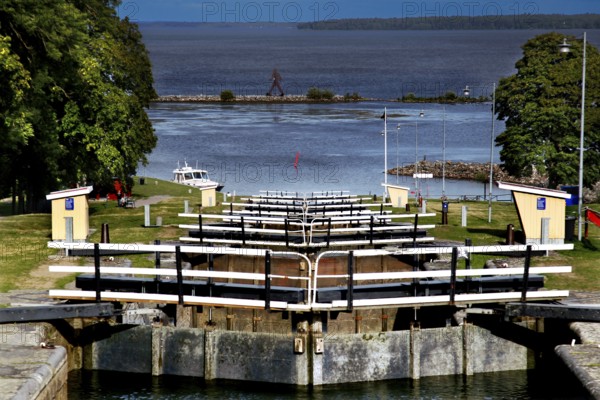 Lock system in the Göta Canal near mountain, with water and surrounding landscape under wide sky,