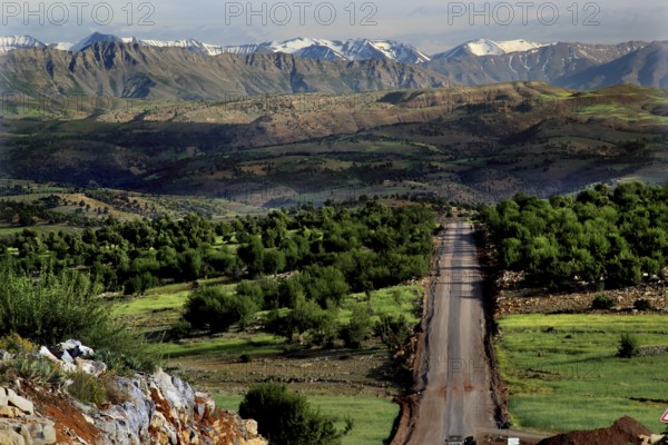 Panoramic view of a road leading through the green landscape of the High Atlas Mountains, Azilal,