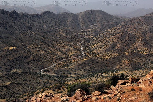 Wasteland landscape with a winding road and barren vegetation in the mountains, Anergui, zero,