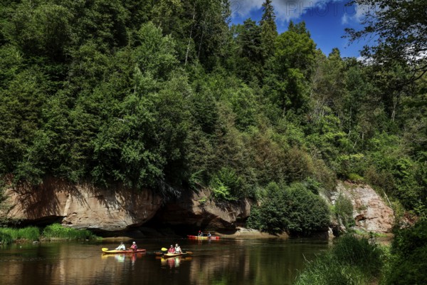 Lined river in Gauja National Park with canoe and steep rocks in the background, Gauja National