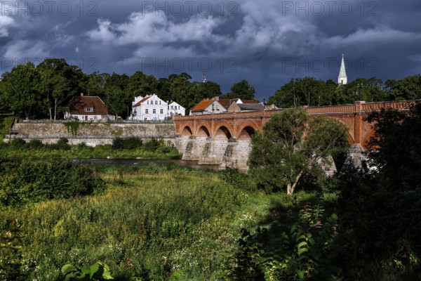 Historic brick bridge across the Venta near Kuldiga, surrounded by lush vegetation, Kuldiga,