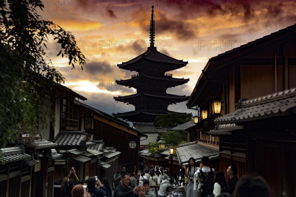 Yasaka Pagoda at sunset, framed by traditional architecture and a dramatic sky, Kyoto, Higashiyama,