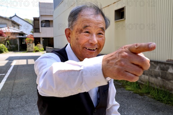 Friendly host points smiling in one direction in Kanazawa, Kanazawa, Japan