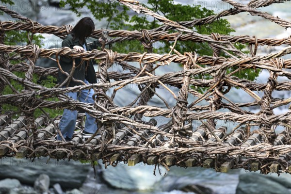 Person crossing the rustic Kazurabashi rope suspension bridge, Iya, Japan