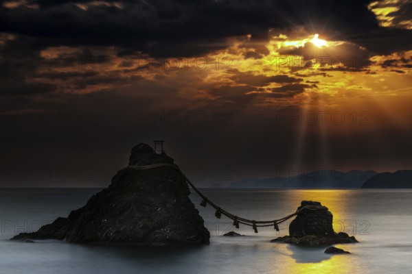 Married rocks at sunrise symbolized by a rope that connects them, Ise, Japan
