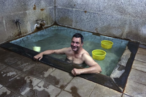 Man relaxing in a traditional public bath in Yamanouchi