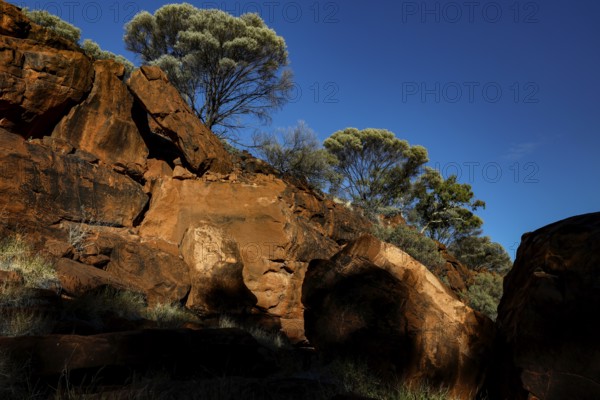 Massive rock formations with sparse vegetation and deep blue sky, Palm Valley, Northern Territory,