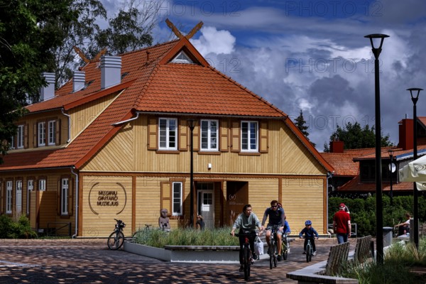 Traditional wooden house on the Curonian Spit with playing children and family, Nida, Curonian