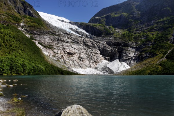 Bøyabreen Glacier Range stretches majestically against a blue sky, surrounded by steep mountains